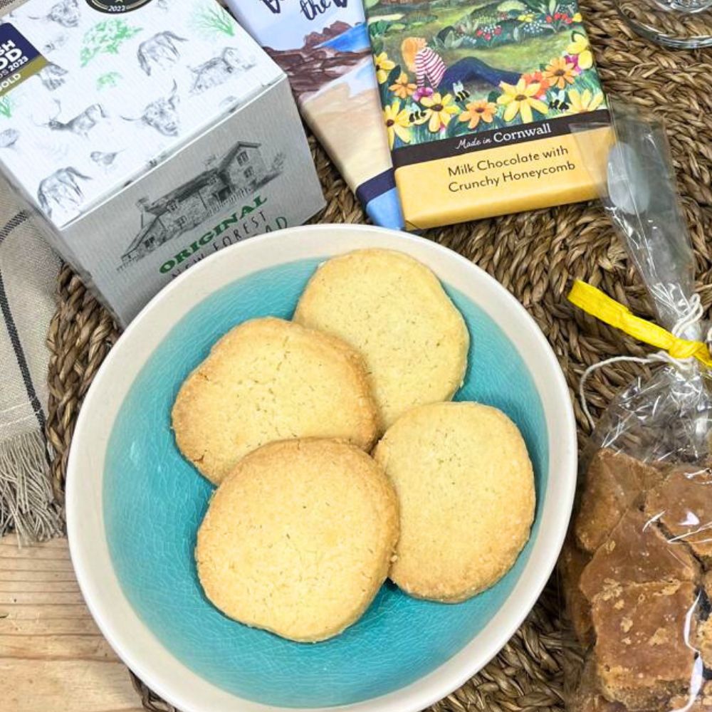 Biscuits in a bowl with chocolate bars and other items on a textured surface